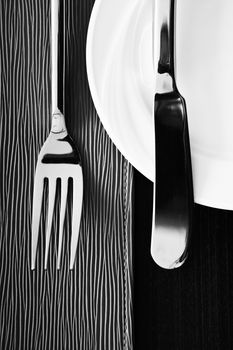 Knife, fork and plate on texture  background