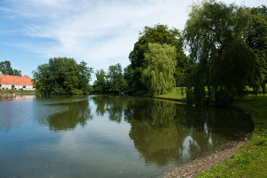 Beautifuln garden with  lawns and trees by a lake in classical mansion estate Denmark