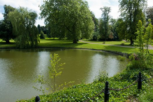 Beautifuln garden with  lawns and trees by a lake in classical mansion estate Denmark