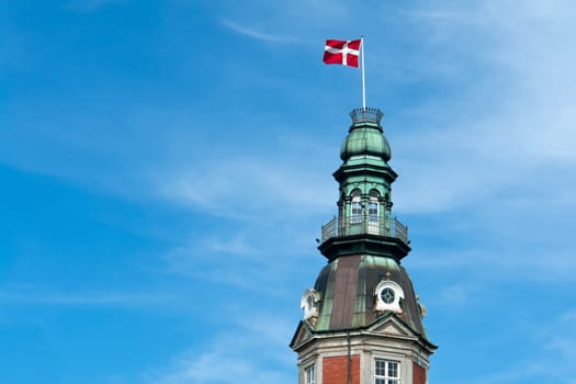 Flag of Denmark up high in the air with blue sky horizontal background