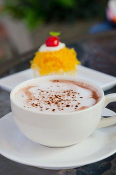 hot cappuccino  in white coffee cup and sweet cake