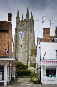 Tenterden church tower at the end of an alley between two shops