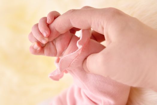 Child's hand holding an mother finger.