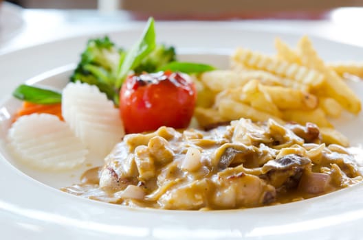 beef steak with mushrooms sauce and vegetable and french fries