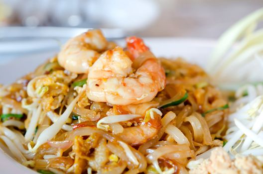 close up stir fry noodles with shrimp , egg  and fresh vegetable on white dish