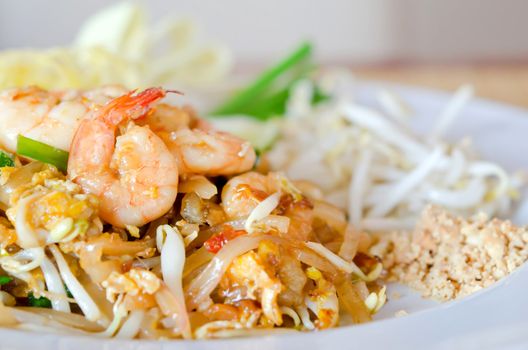 thai food , stir fry noodles with shrimp , egg  and fresh vegetable on white dish