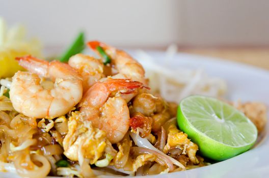 Stir fry noodles with shrimp , egg  and  vegetable served with fresh lemon