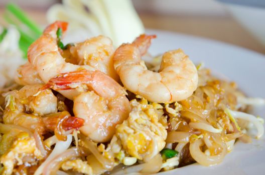 Stir fry noodles with shrimp , egg  and  vegetable on white plate