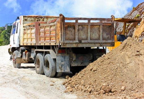 A truck is dump  soil  on an excavation site