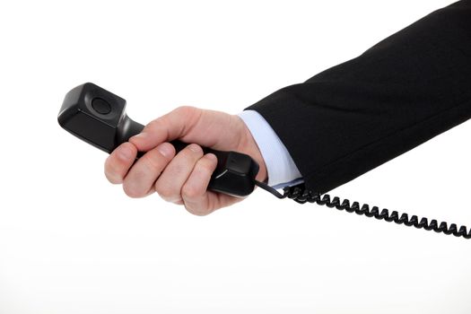 A cropped picture of a businessman holding landline phone.