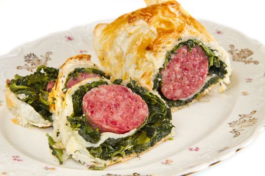 italian cotechino in crust with spinach on dish