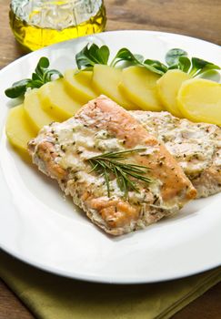 white dish with salmon fillet and potatoes