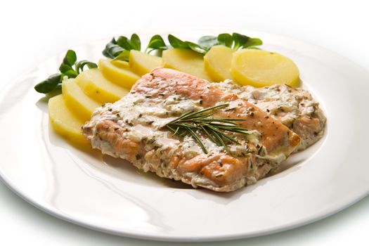 white dish with salmon fillet and potatoes