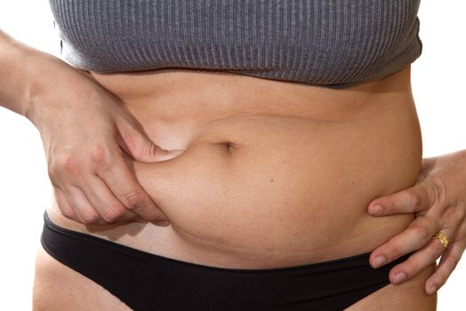 Woman's fingers measuring her belly fat