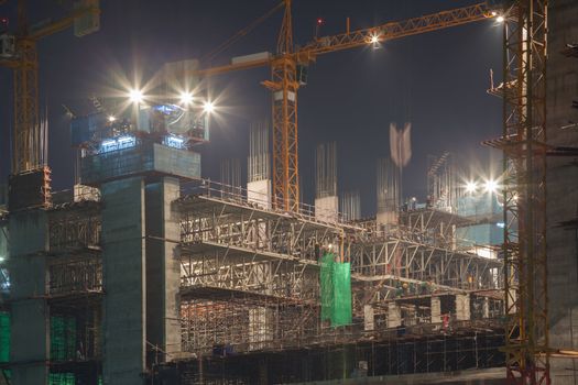 construction site with moving crane at dusk