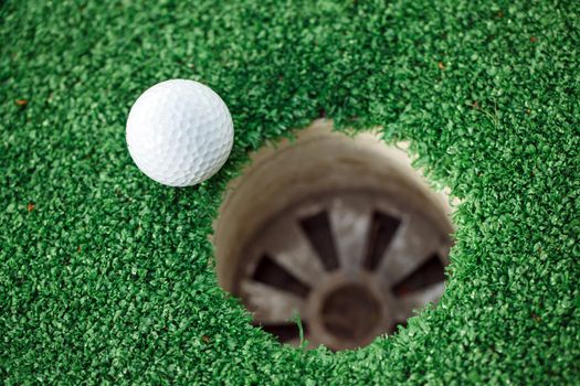 golf ball on lip of cup
