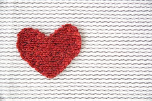 red heart on striped fabric background