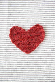 red heart put on white striped fabric