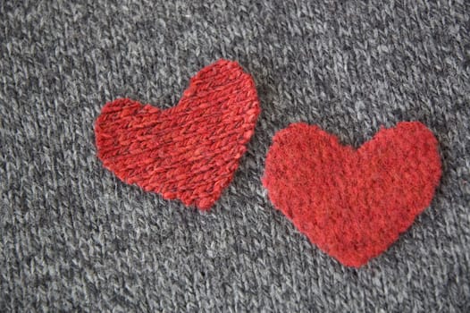 two red hearts put together on dark fabric