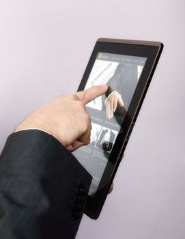 Finger touching screen on tablet-pc and browsing a website.The Website from the image was created by me and the pictures used can be found in my portfolio