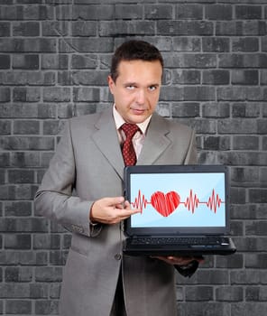 man with a laptop in hand points to heartbeat on screen
