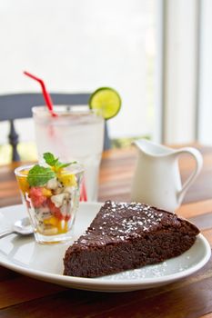 Chocolate fondant cake with fruit salad and lime juice