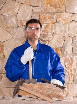 Masonry mason stonecutter man with hammer working on stone wall construction