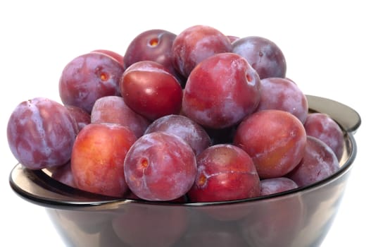 Ripe plums on a plate isolated on a white background.