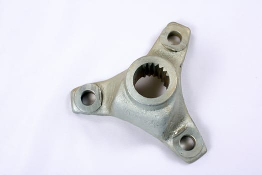 A newly manufactured part of a modern car engine, on white fabric background.