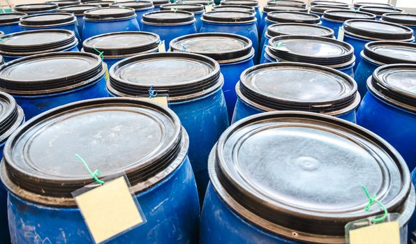 blue plastic industrial barrels for storage of chemicals in factory