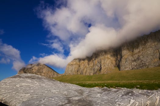 Heavy clouds forming on the top of picturesque coastal cliff in Norway