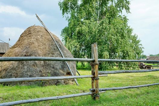 Haystack and birch tree in the village of summer.