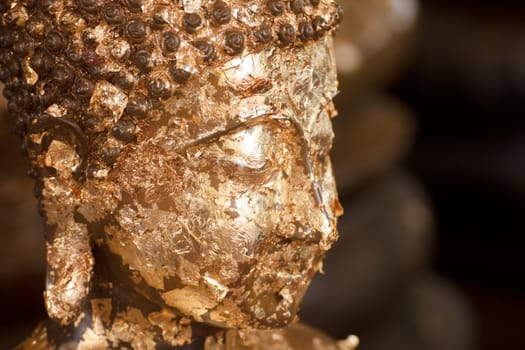 Gold face of statue Buddha with gold leaf attached