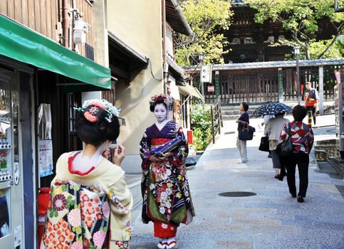 KYOTO, JAPAN - OCT 21 2012: Japanese ladies in traditional dress  on a street leading to Kiyomizu Temple on October 21 2012. Kiyomizu is a famous temple in Kyoto built in year 778.
