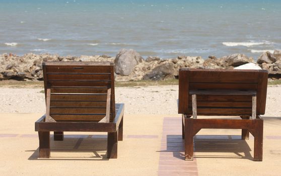 Young woman sitting on a bench at the beach