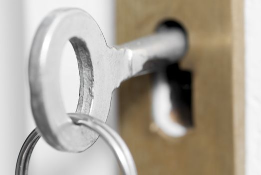 Macro photo of old style house key in door lock.
