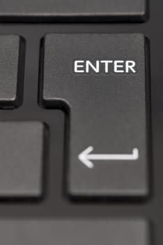 Detail of enter key on black laptop.