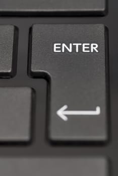 Detail of enter key on black laptop.