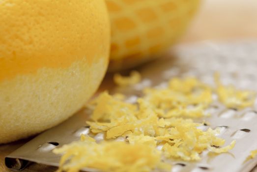 Zested lemons on wooden chopping board.