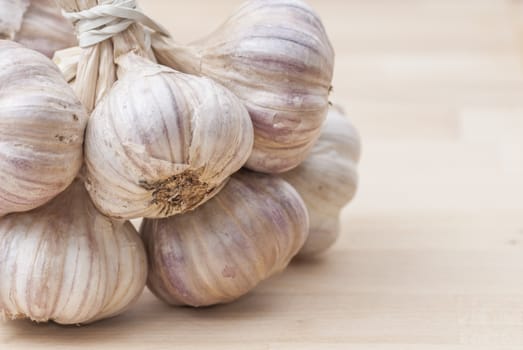 Macro image of garlic against wooden background.