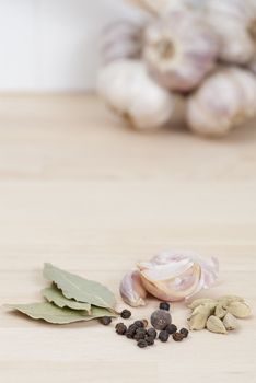 Garlic, Peppercorns, Bay Leaves on wooden kitchen surface