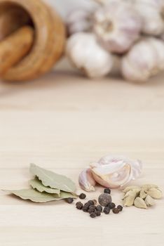 Garlic, Peppercorns, Bay Leaves on wooden kitchen surface