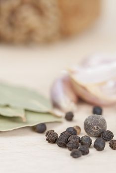 Garlic, Peppercorns, Bay Leaves on wooden kitchen surface