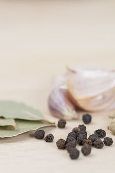 Garlic, Peppercorns, Bay Leaves on wooden kitchen surface