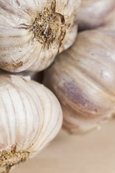 Macro image of garlic bulbs on wooden surface.