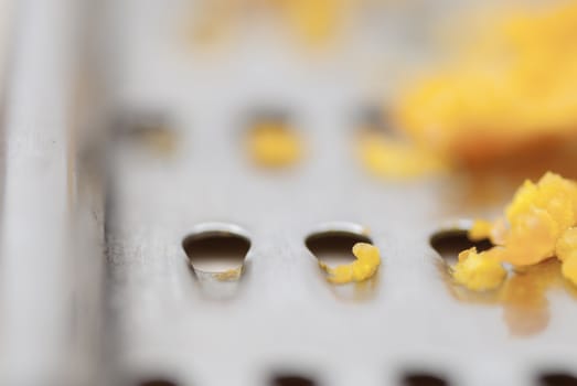 Grater and citrus zest on wooden kitchen surface.