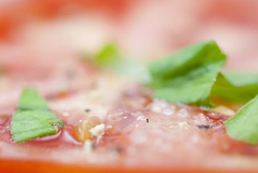 Macro image of slices of Tomato prepared with oilive oil, basil, pepper & salt.