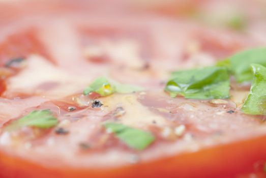 Macro image of slices of Tomato prepared with oilive oil, basil, pepper & salt.