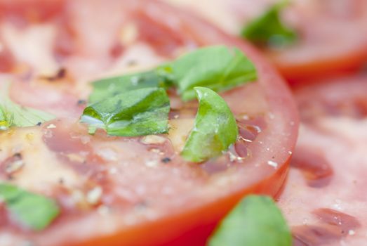 Macro image of slices of Tomato prepared with oilive oil, basil, pepper & salt.