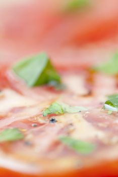 Macro image of slices of Tomato prepared with oilive oil, basil, pepper & salt.